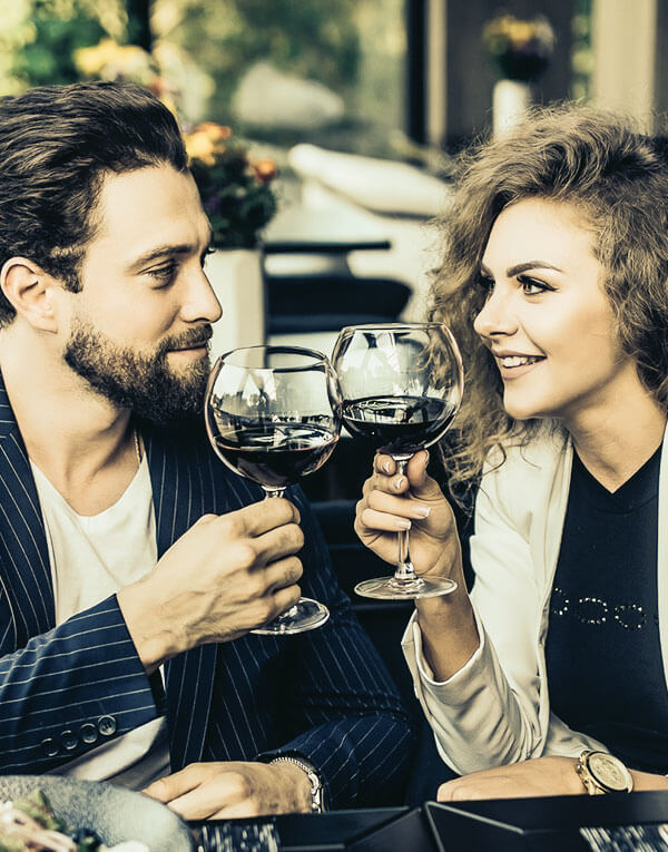 Couple staring at each other, drinking wine